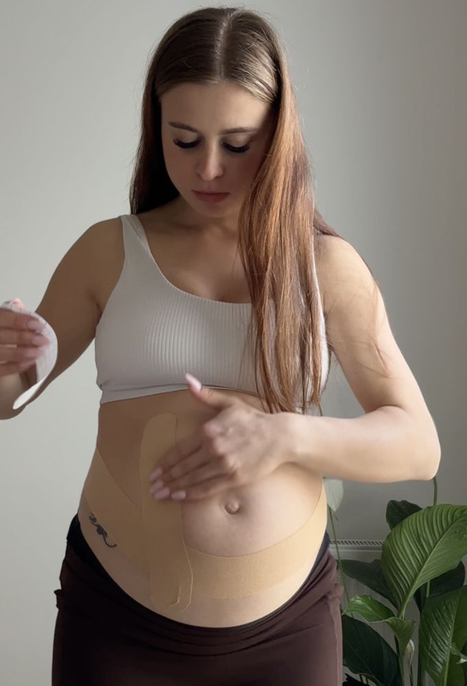 Natalia taping her pregnant belly